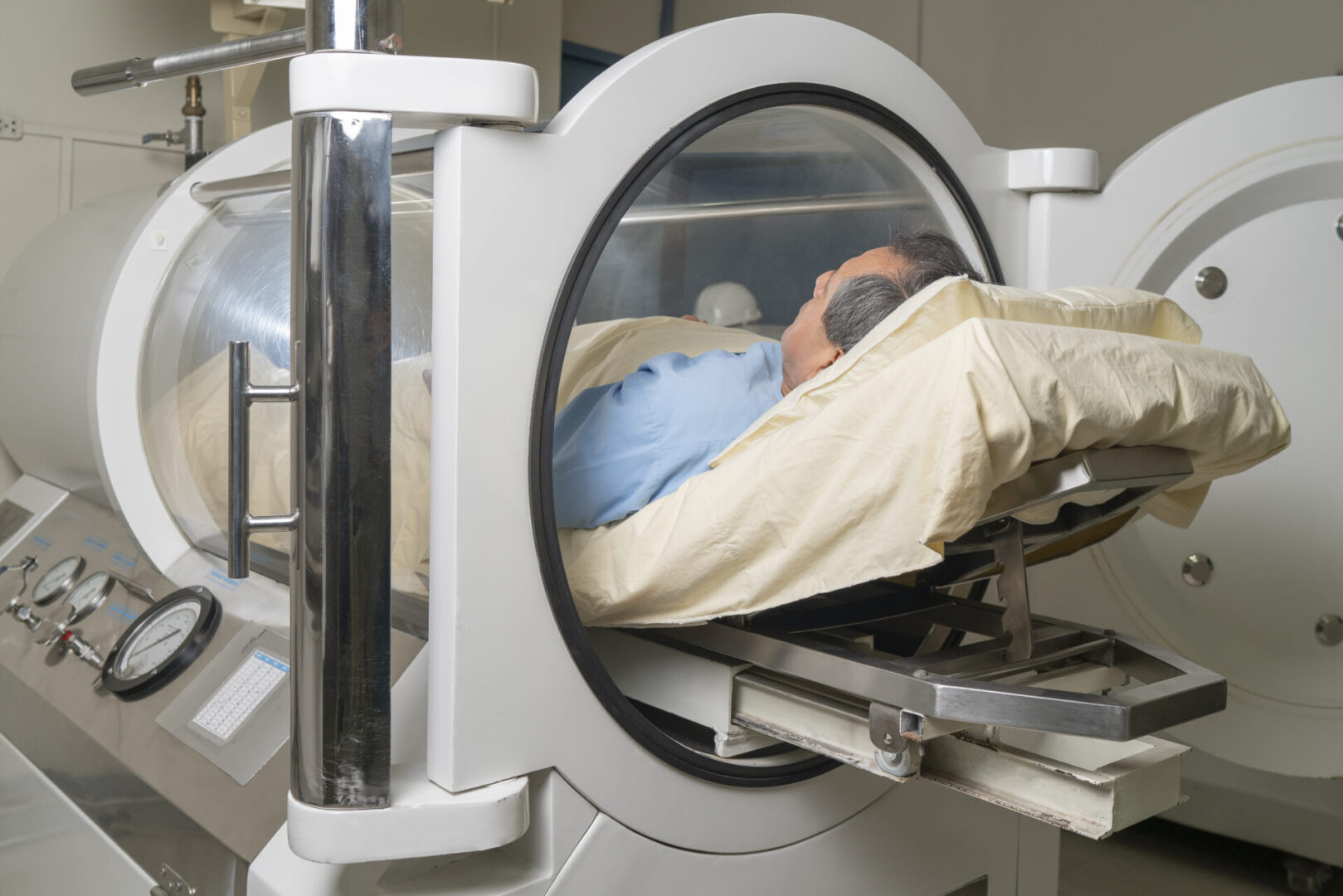 A person lying inside a hyperbaric oxygen therapy chamber.