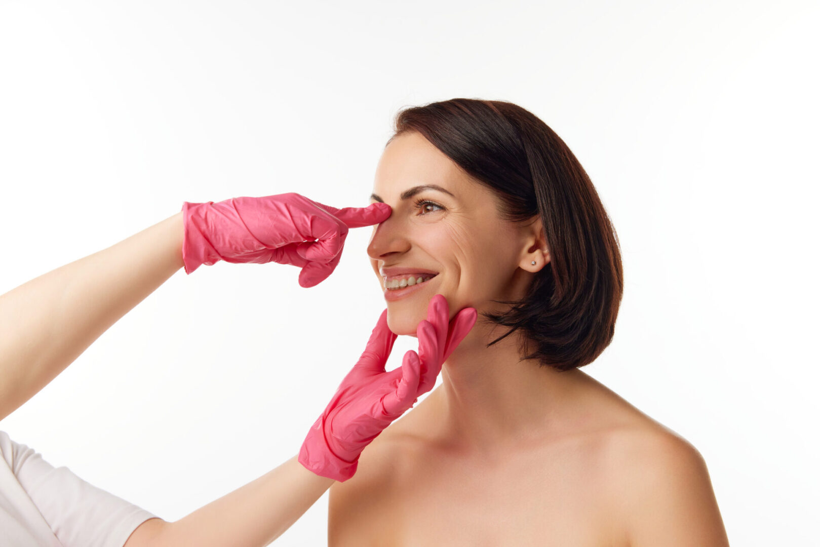Woman wearing pink gloves pinching her nose.
